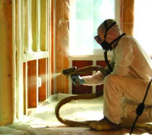 A technician spraying insulation into a wall